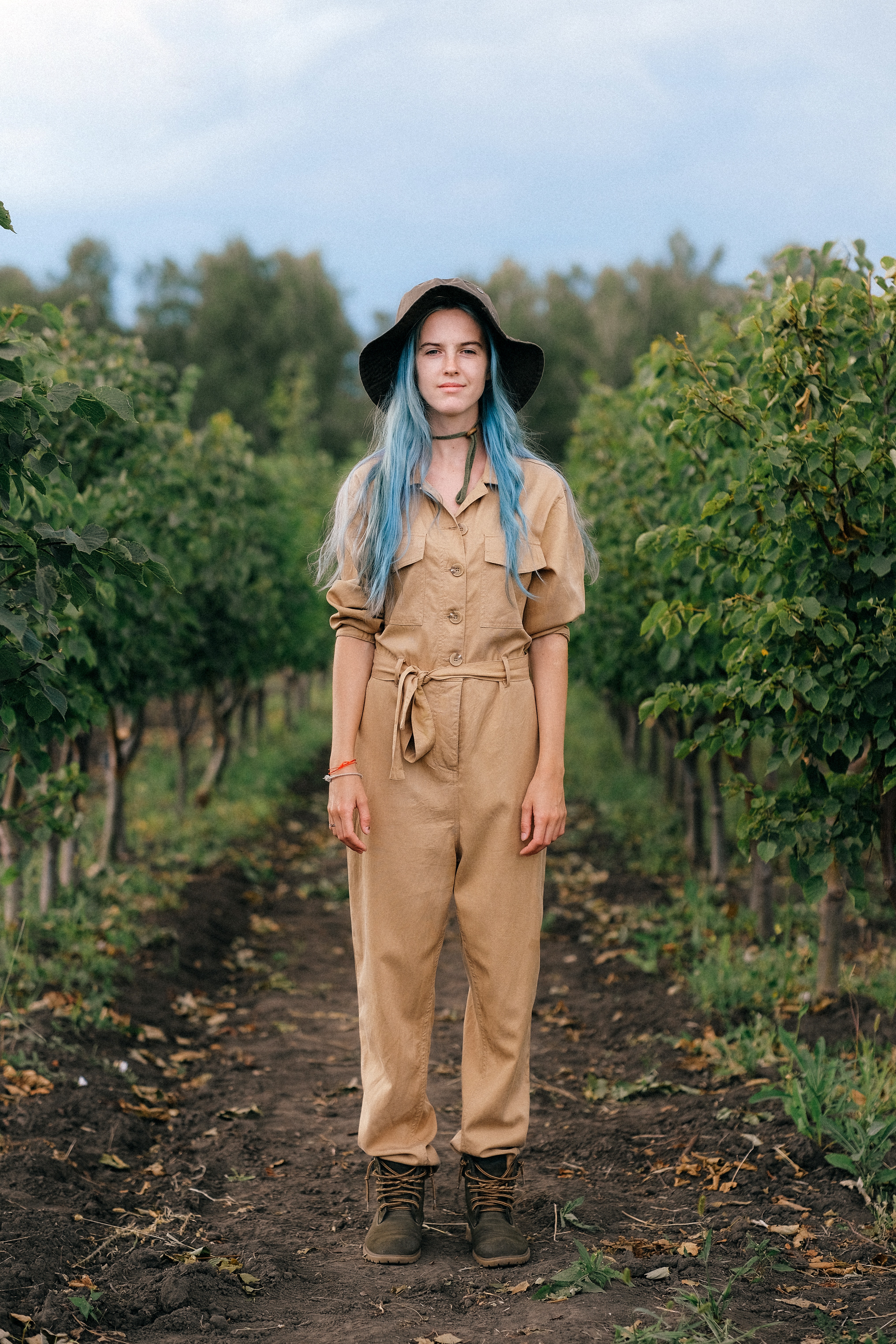 a woman with blue hair standing outside